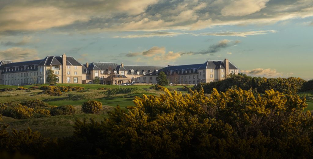 Scenic image of a large and beautiful historic building surrounded by a forest of autumnal trees.
